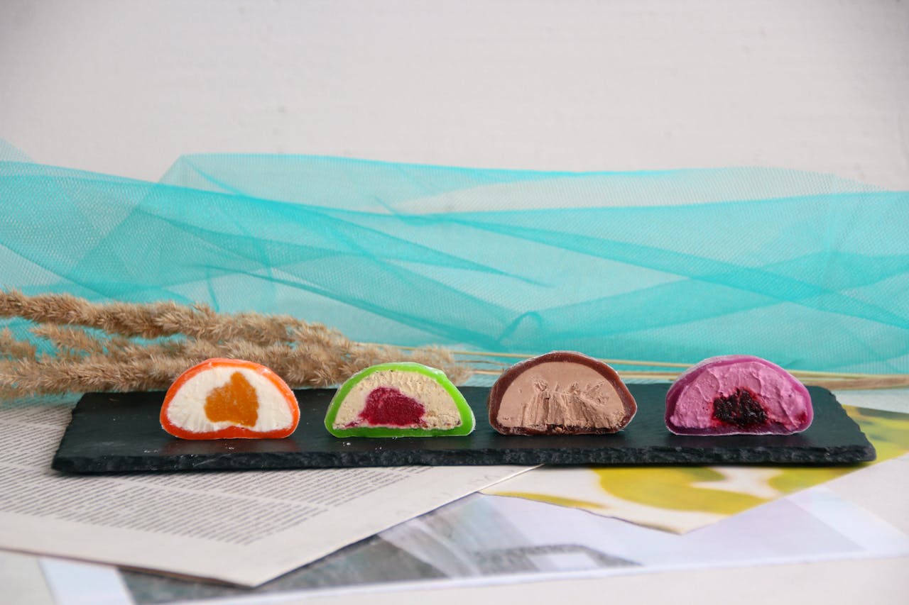 Colorful mochi treats displayed on a slate platter, showcasing a variety of fillings.